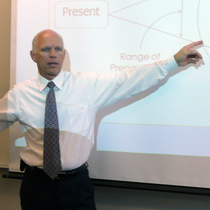 Dr. Merle Switzer pointing to a diagram during a speaking engagement